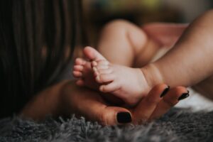 An adorable baby, barefoot and full of joy, expressing affection.